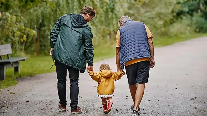 Tre generationer der går på en sti og holder i hånden